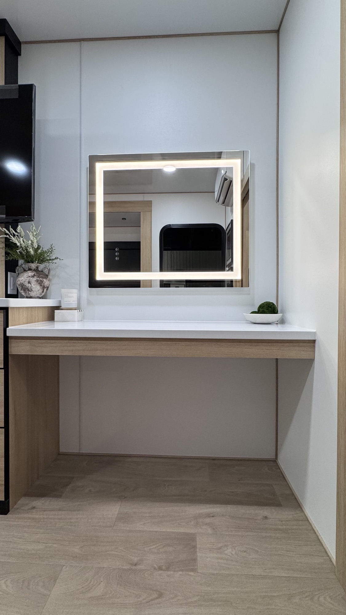 Floating white quartz vanity desk with backlit Hollywood-style LED mirror in the Model A workspace