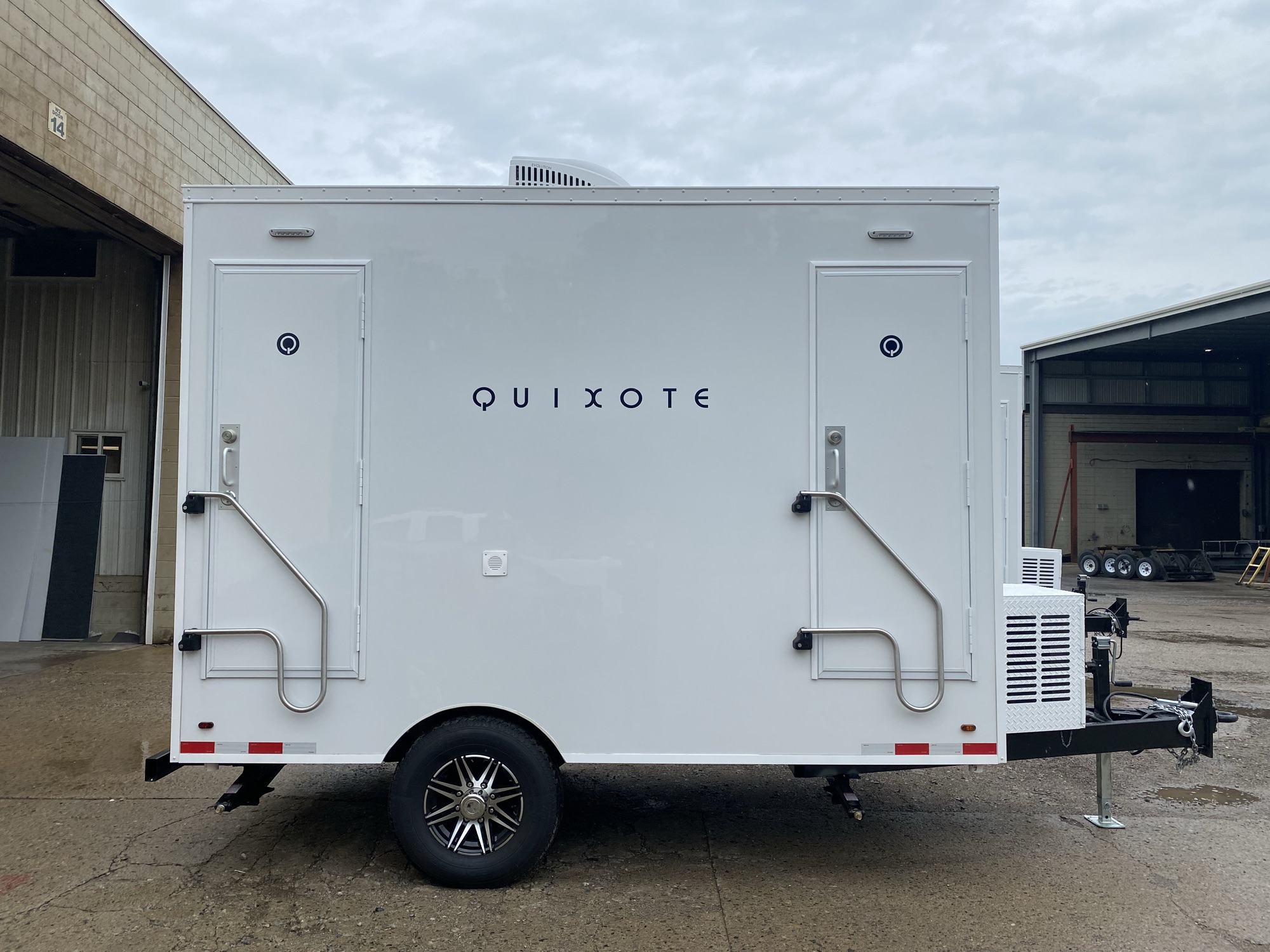 Side profile of 2-stall luxury restroom trailer showing both stall doors and compact footprint