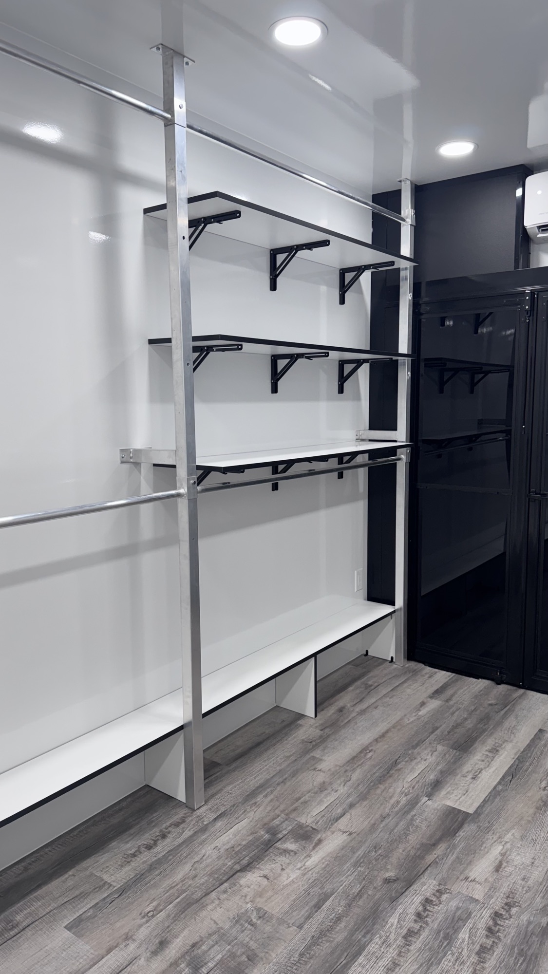 Adjustable shelving and black wardrobe lockers inside the trailer with mini-split climate control